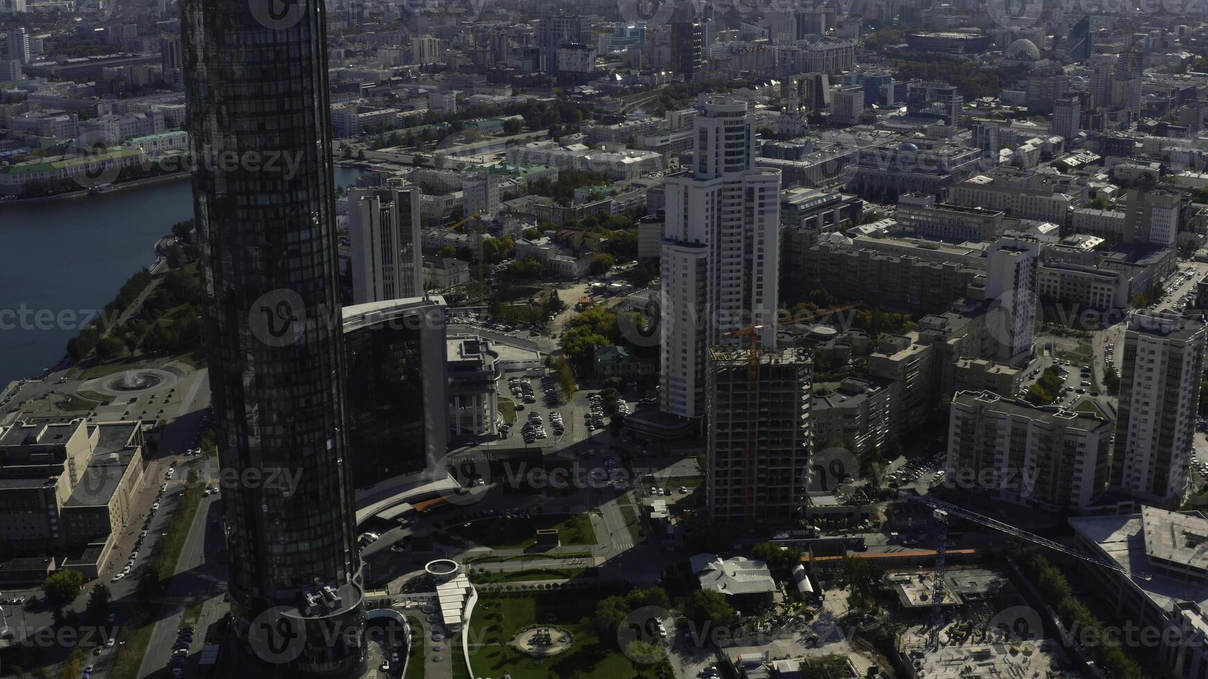 oben Aussicht von Konstruktion von Gebäude im Stadt Center mit Hochhaus Gebäude. Lager Filmaufnahme. Landschaft von Stadt mit Hochhaus Gebäude und Gebäude unter Konstruktion im Center. schön Sommer- foto