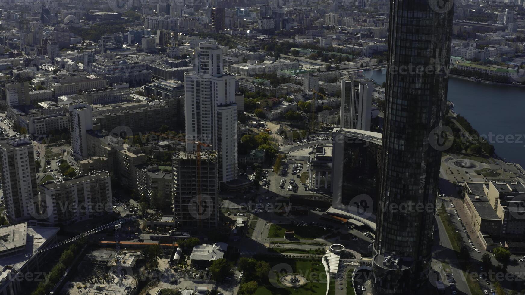 oben Aussicht von Konstruktion von Gebäude im Stadt Center mit Hochhaus Gebäude. Lager Filmaufnahme. Landschaft von Stadt mit Hochhaus Gebäude und Gebäude unter Konstruktion im Center. schön Sommer- foto