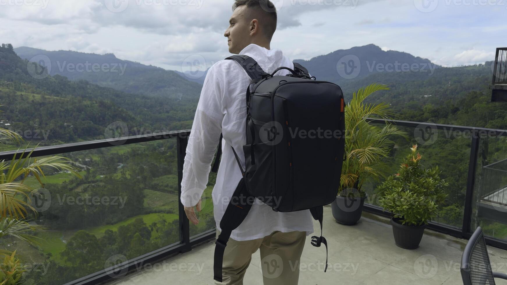 Mann mit Aussicht von tropisch Berg Schlucht. Aktion. Mann auf Überwachung Deck im tropisch Berge. Mann mit Rucksack auf Besichtigung Attraktion mit Blick auf Grün Berge foto