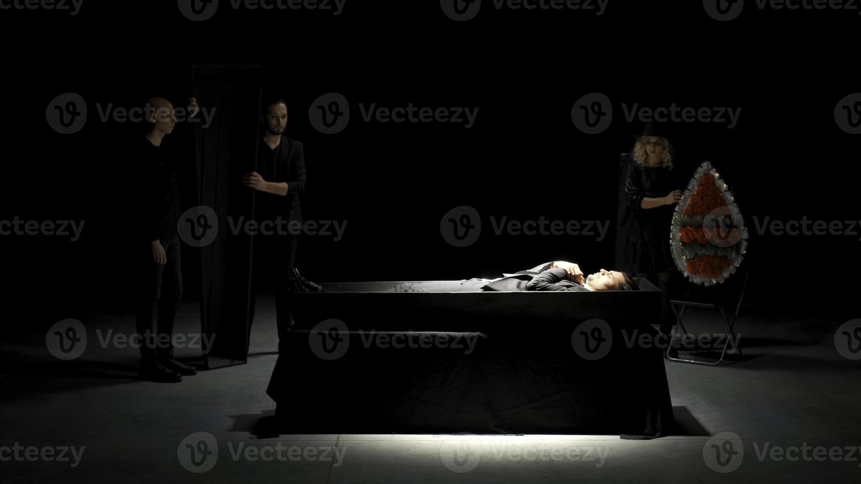 theatralisch Beerdigung. Lager Filmaufnahme. Mann im passen ist begraben auf Theater Bühne. emotional Bühne Produktion von Beerdigung foto