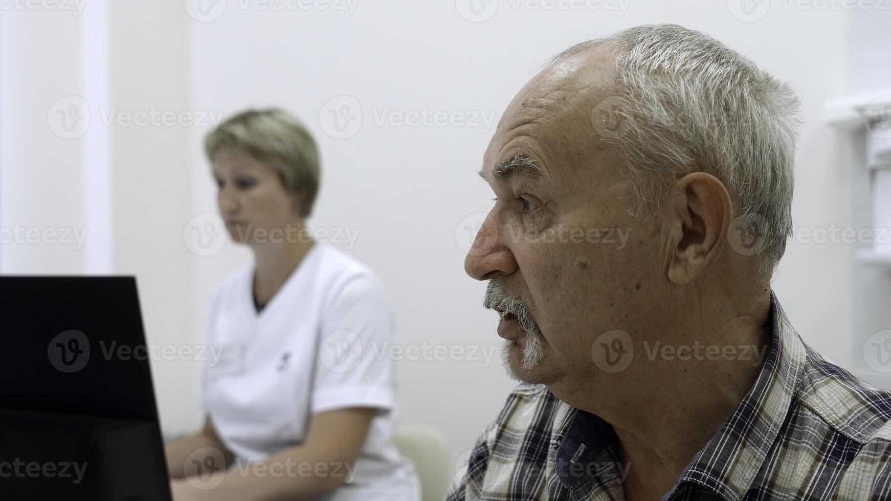 Porträt von ein alt Mann geduldig reden zu Arzt mit weiblich Krankenschwester hinter. Clip. Konzept von Öffentlichkeit Gesundheit Dienstleistungen. foto