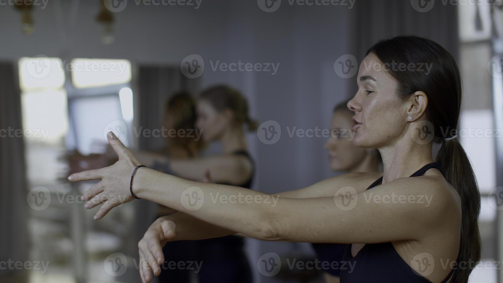 Frau Trainer durchführen Ausbildung trainieren zum weiblich Gruppe. Medien. Mentor erklären das Technik von Atmung mit Hände schwingt. foto