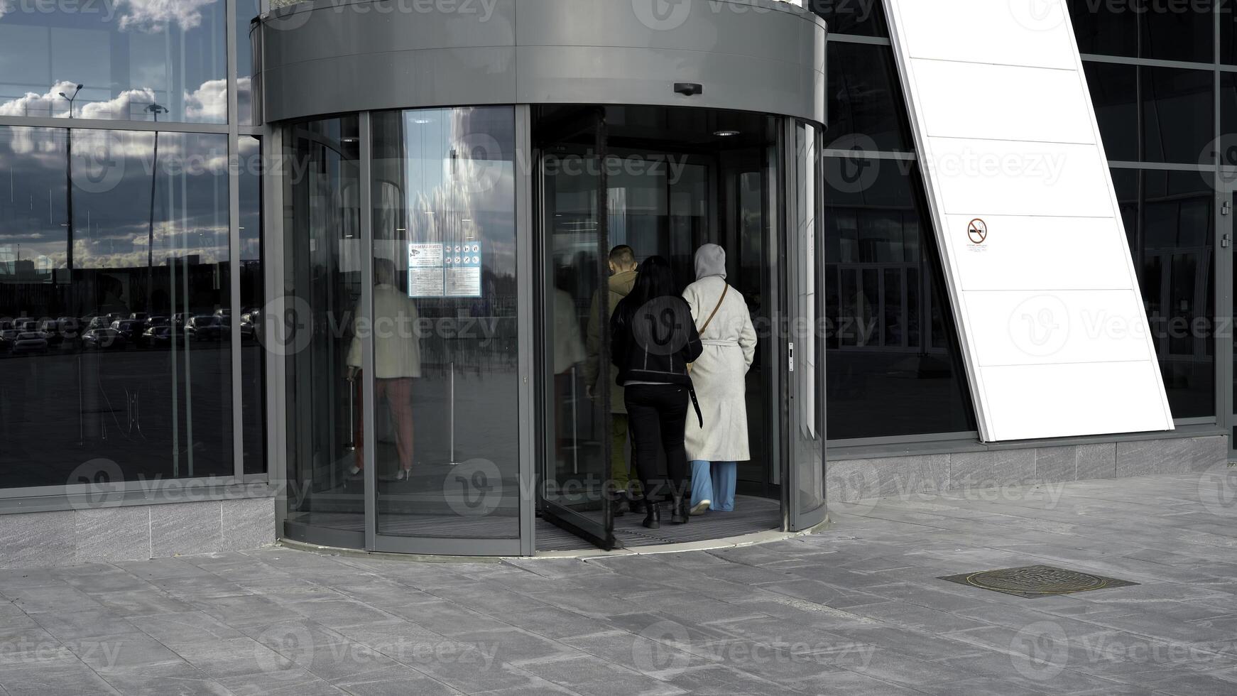ein drehend Tür im modern Gebäude, Einkaufen Center. Medien. Glas rotierend Tür, Drehscheibe Eingang zu das Geschäft Center, Zeit Ablauf. foto
