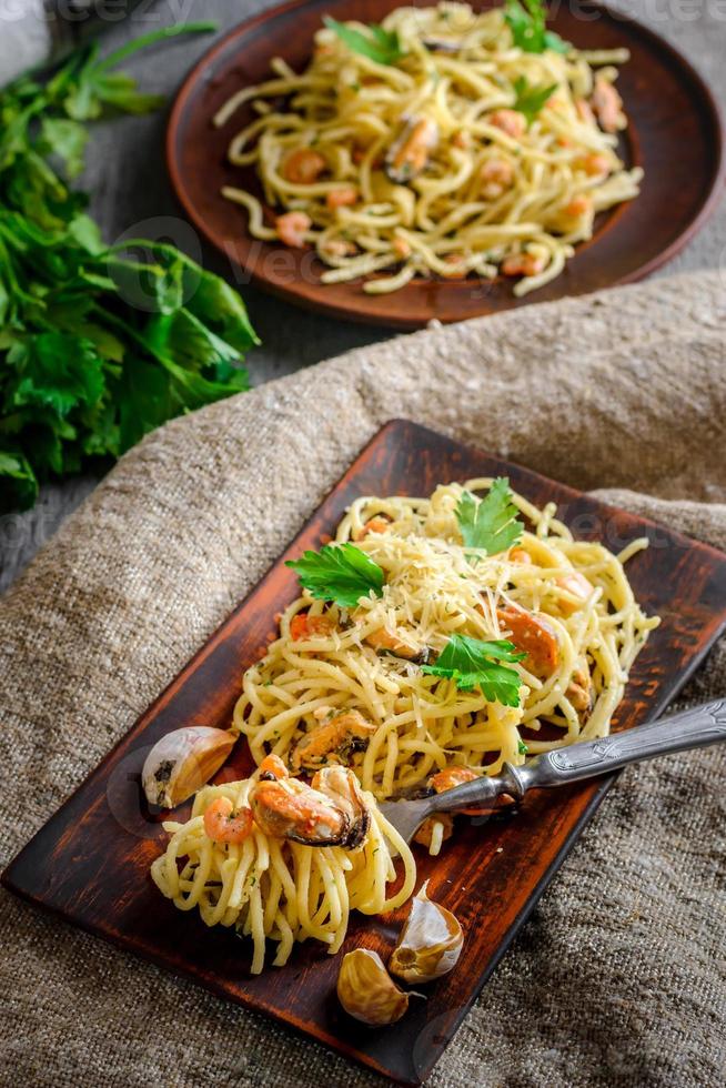 italienische Pasta in cremiger Sauce mit Meeresfrüchten, Garnelen und Muscheln auf einem Teller foto
