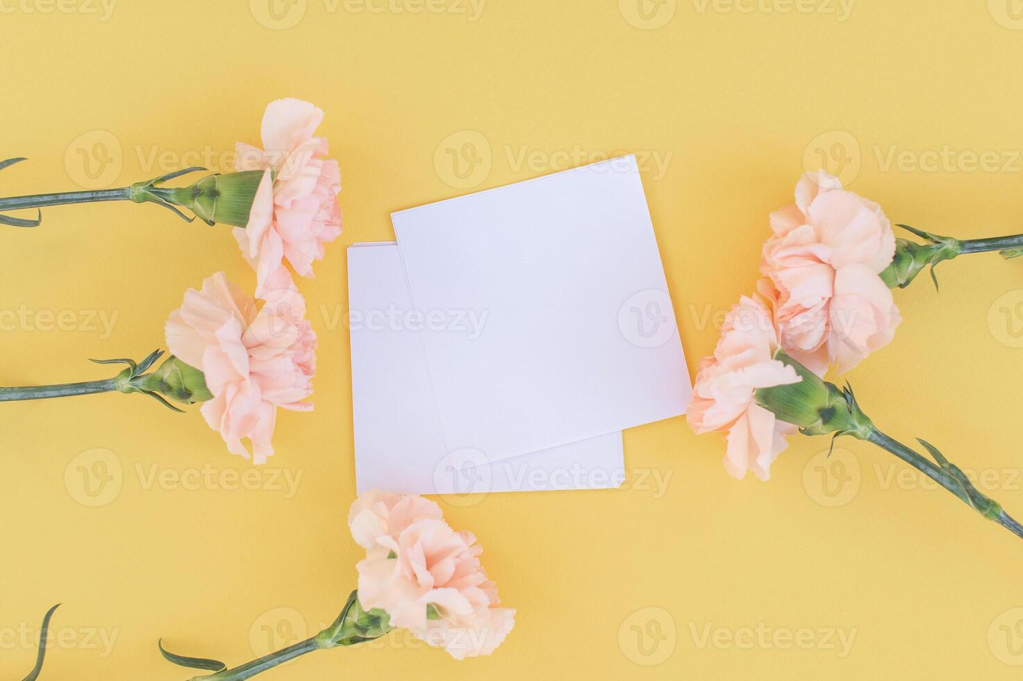 Strauß von Blumen Gelb Nelken Lüge mit ein Notizblock auf ein Rosa Hintergrund. Aussicht von über. foto