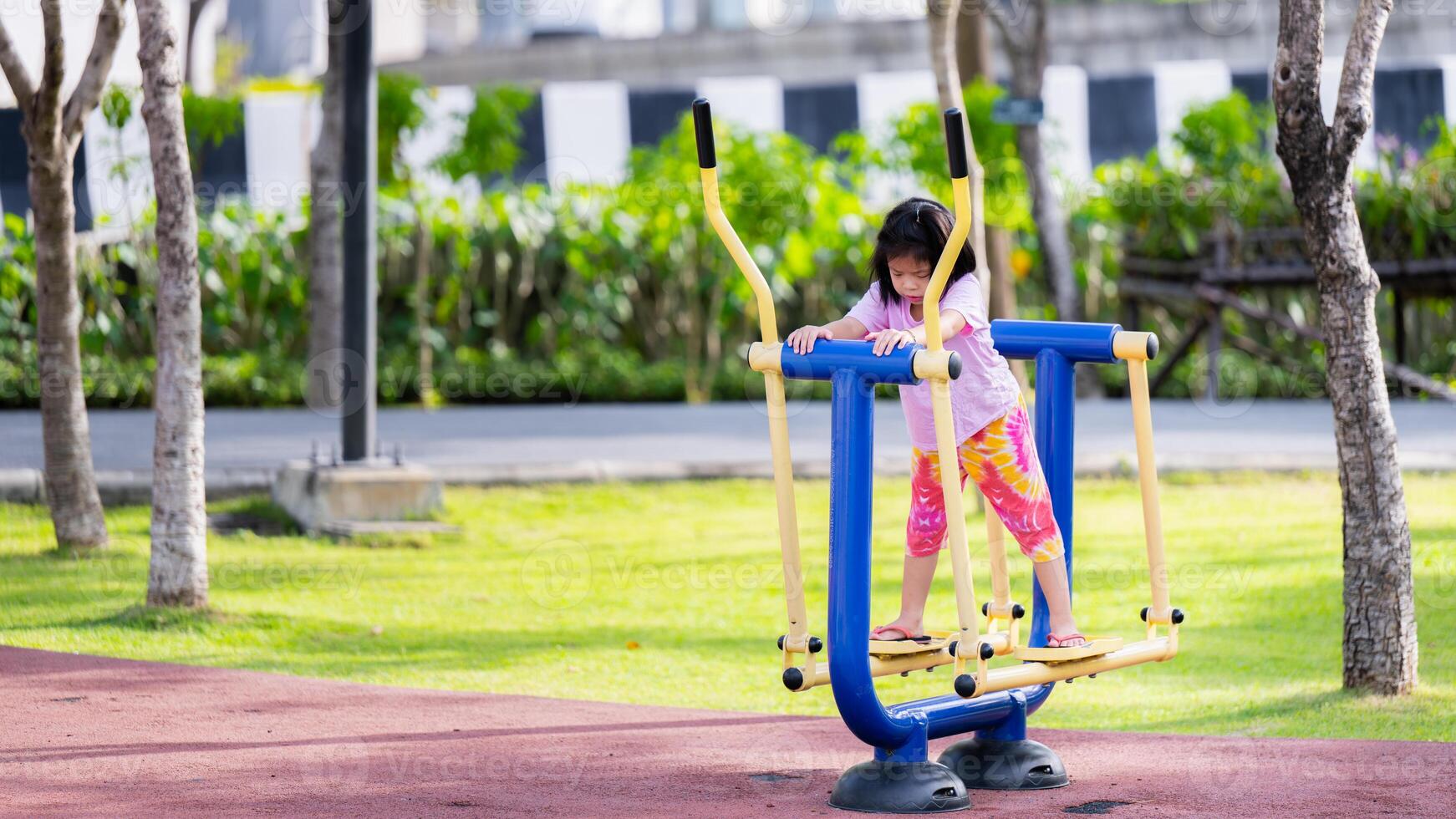 asiatisch Mädchen auf schwingen im Park, umgeben durch Natur im Spielplatz, lächelnd Dame genießen draussen Übung auf sonnig Sommer- Tag, wenig Tochter genießen und haben Spaß Lebensstil Wochenende Aktivität im Sommer. foto