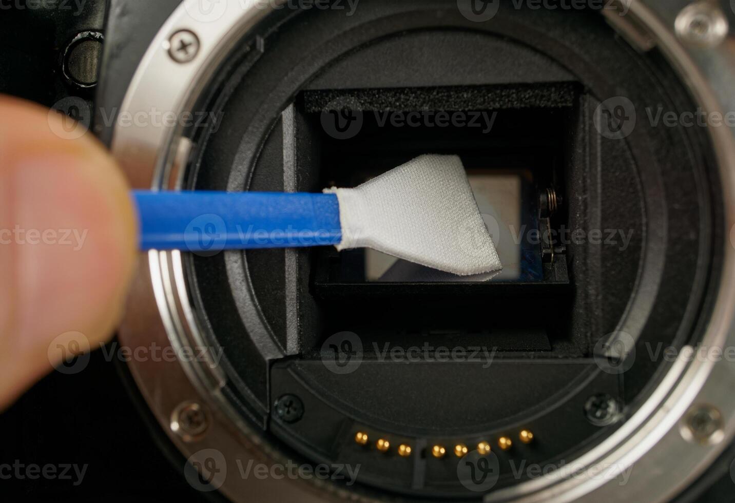 Techniker reinigt Sensor von Digital Kamera von Staub und Schmutz foto