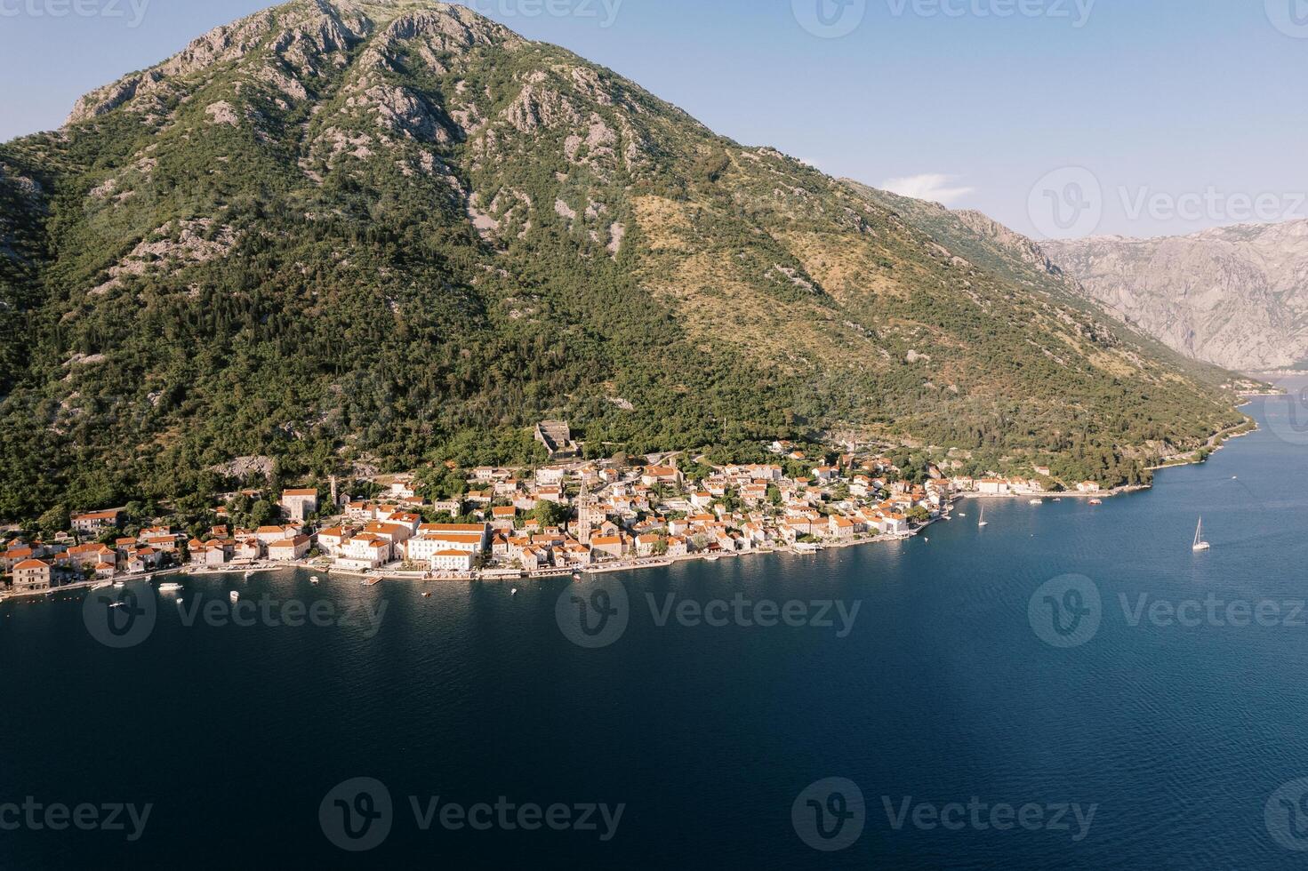 uralt Häuser mit rot Dächer beim das Fuß von Grün Berge auf das Küste von pesas. Montenegro. Drohne foto