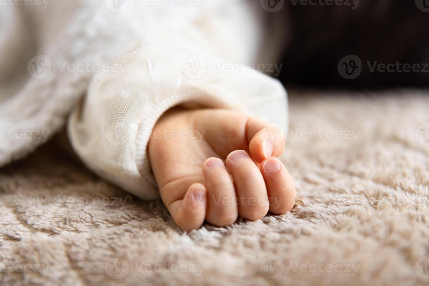 ein links Hand von Schlafen asiatisch Baby auf das Teppich foto