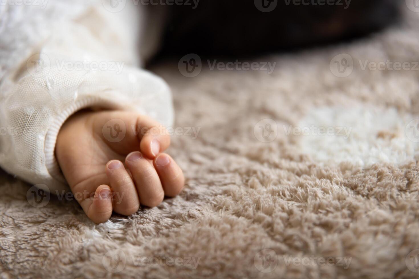 ein links Hand von Schlafen asiatisch Baby auf das Teppich foto