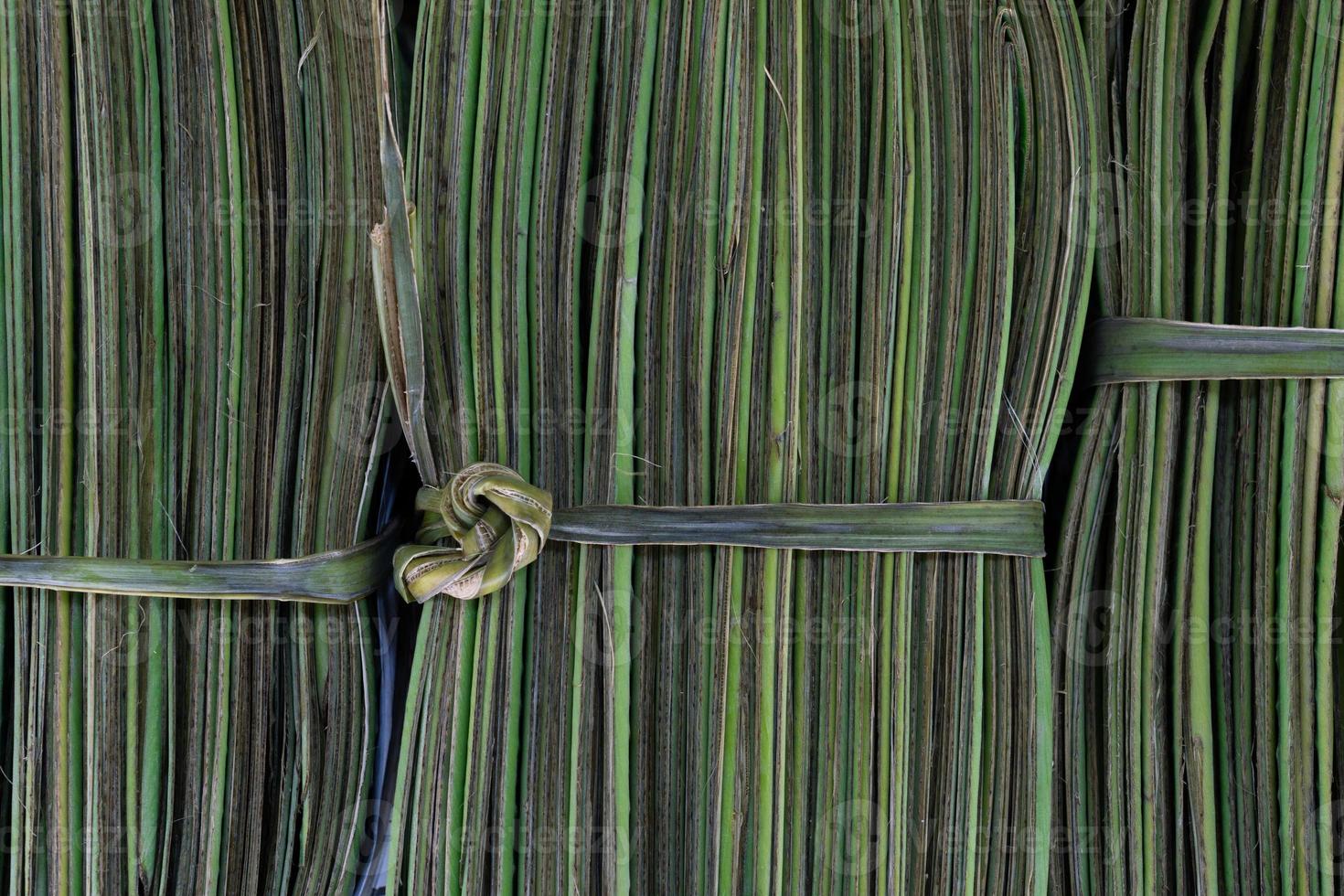 Nahaufnahme von grünen Bananenblättern, die sich zu einem Bündel falten, das sich für den Verkauf vorbereitet foto