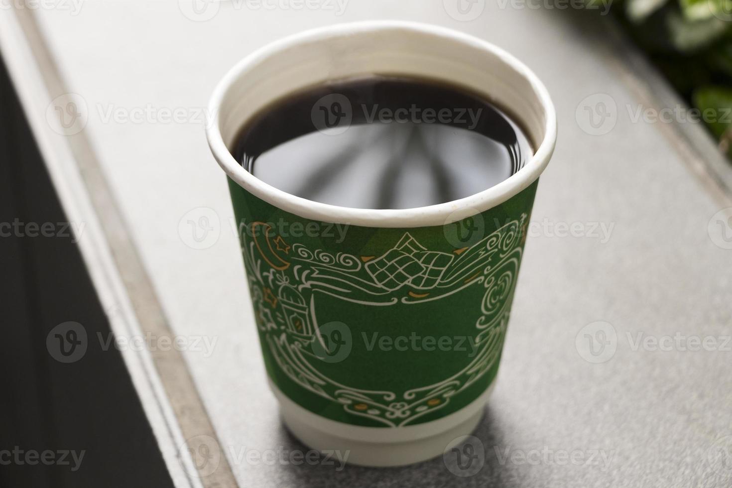 schwarzer kaffee in einem grünen papierbecher wie mc donalds. foto