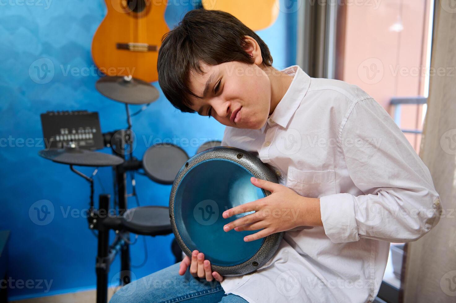 inspiriert Teenager, Musiker hämmern traditionell ethnisch afrikanisch Trommel, Erstellen das Rhythmus von afrikanisch Melodie, Sitzung im ein gemütlich Zuhause Musik- Studio foto