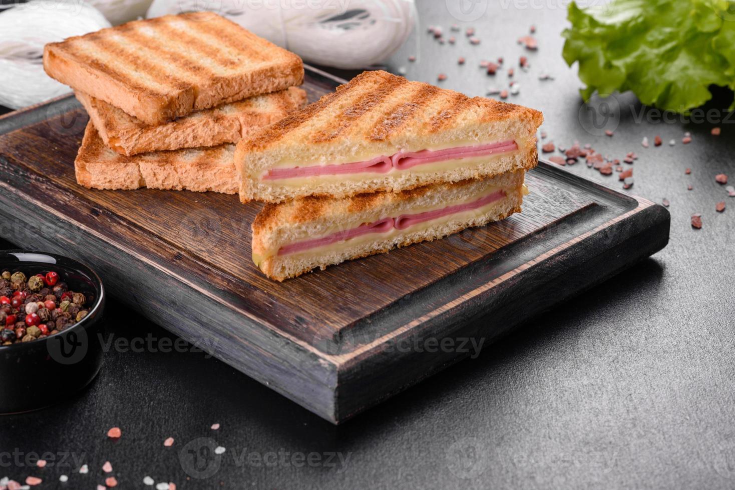 Sandwich mit Schinken, Käse, Tomaten, Salat und Toastbrot foto