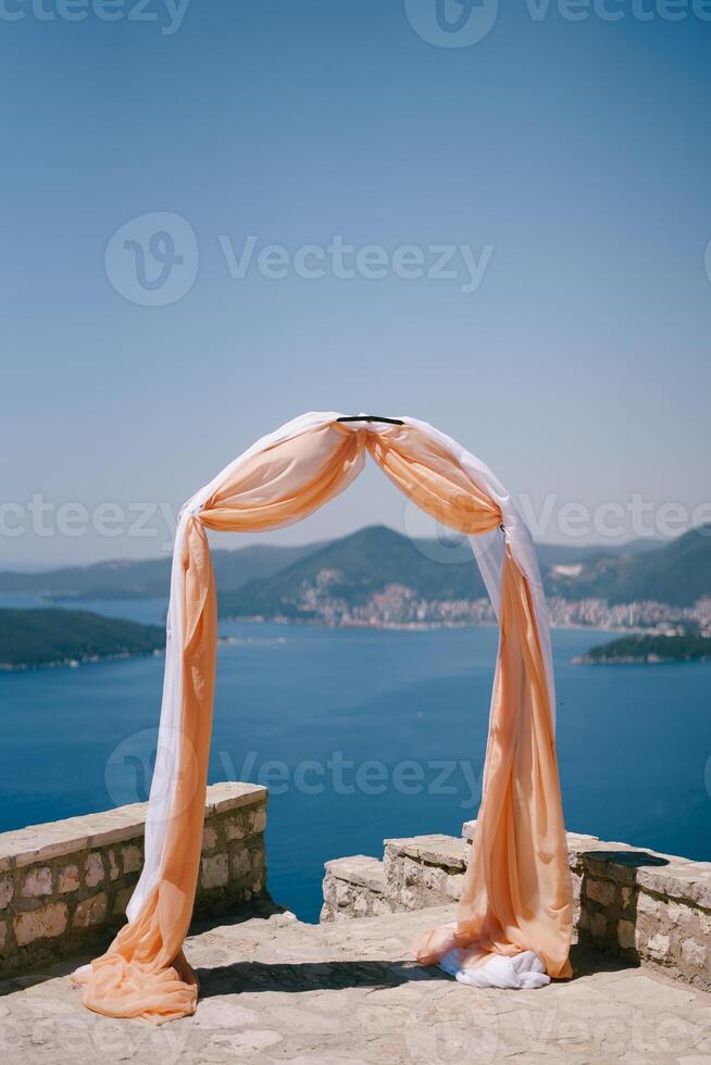 Hochzeit Bogen dekoriert mit Stoff steht auf ein Überwachung Deck über das Meer foto