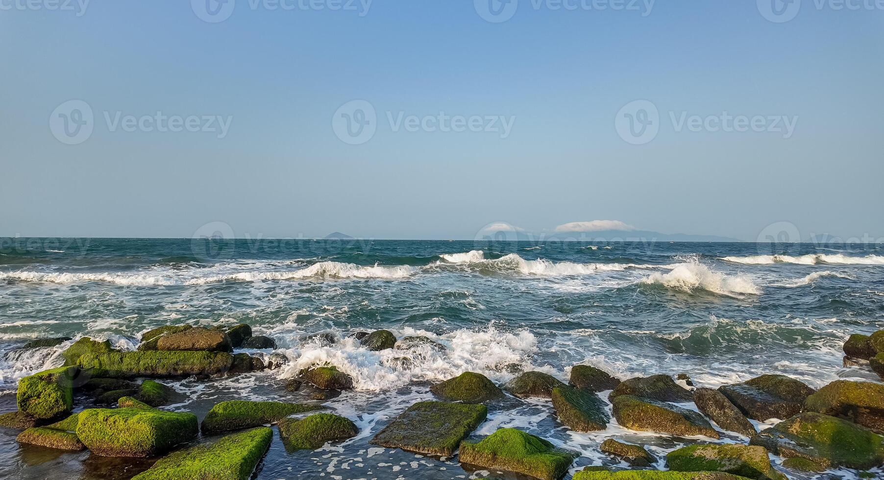 moosig Strand Felsen mit abstürzen Wellen foto