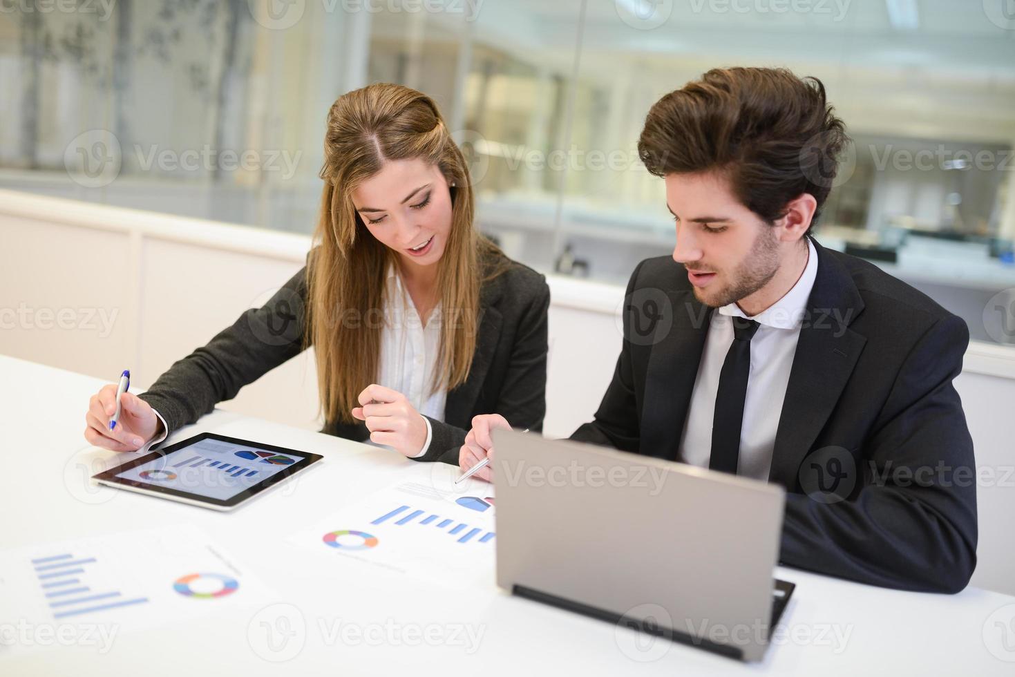 Geschäftsleute, die im modernen Büro am Tisch arbeiten foto