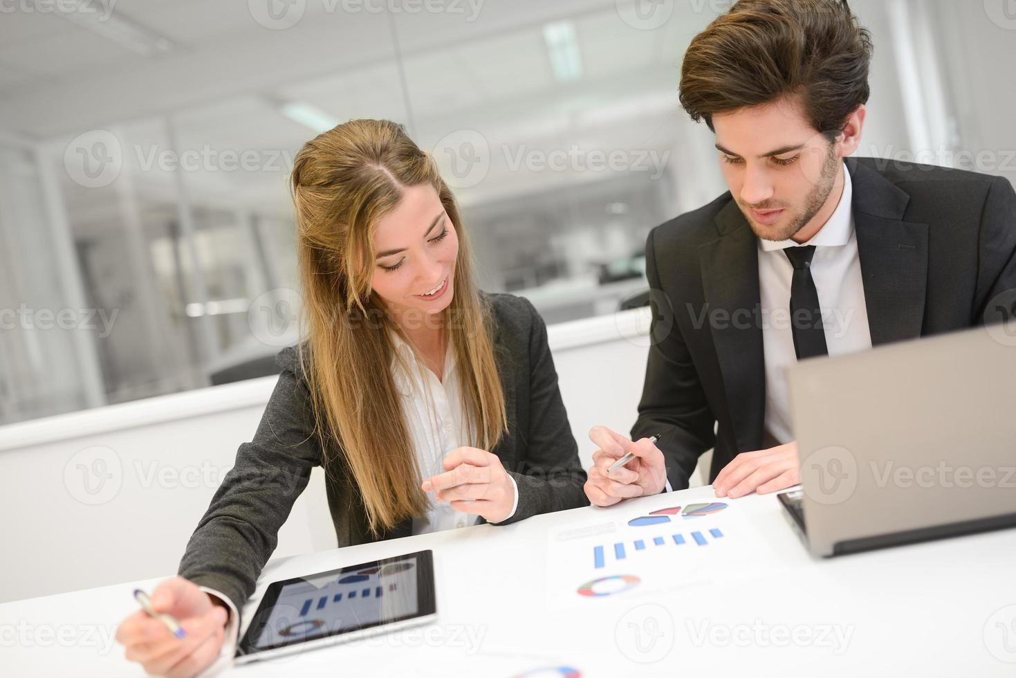 Geschäftsleute, die im modernen Büro am Tisch arbeiten foto