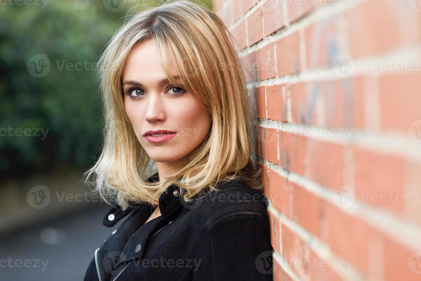 schöne junge blonde Frau im städtischen Hintergrund foto