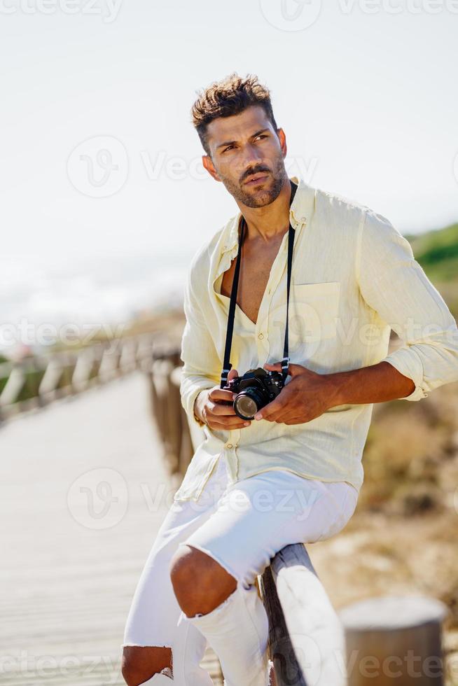 gut aussehender Mann, der in einem Küstengebiet fotografiert. foto