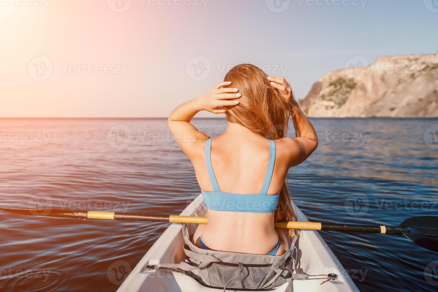 Frau im Kajak zurück Sicht. glücklich jung Frau mit lange Haar schwebend im Kajak auf Ruhe Meer. Sommer- Urlaub Ferien und heiter weiblich Menschen entspannend haben Spaß auf das Boot. foto