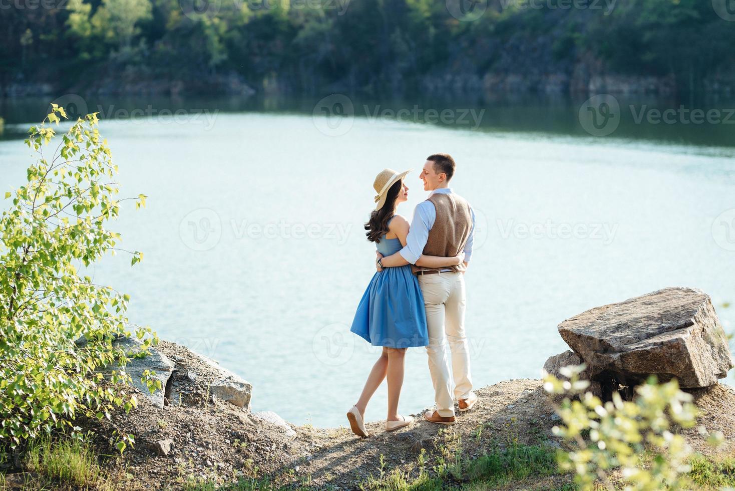 Ein junges Paar, ein Mann und ein Mädchen, gehen in der Nähe eines Bergsees spazieren foto