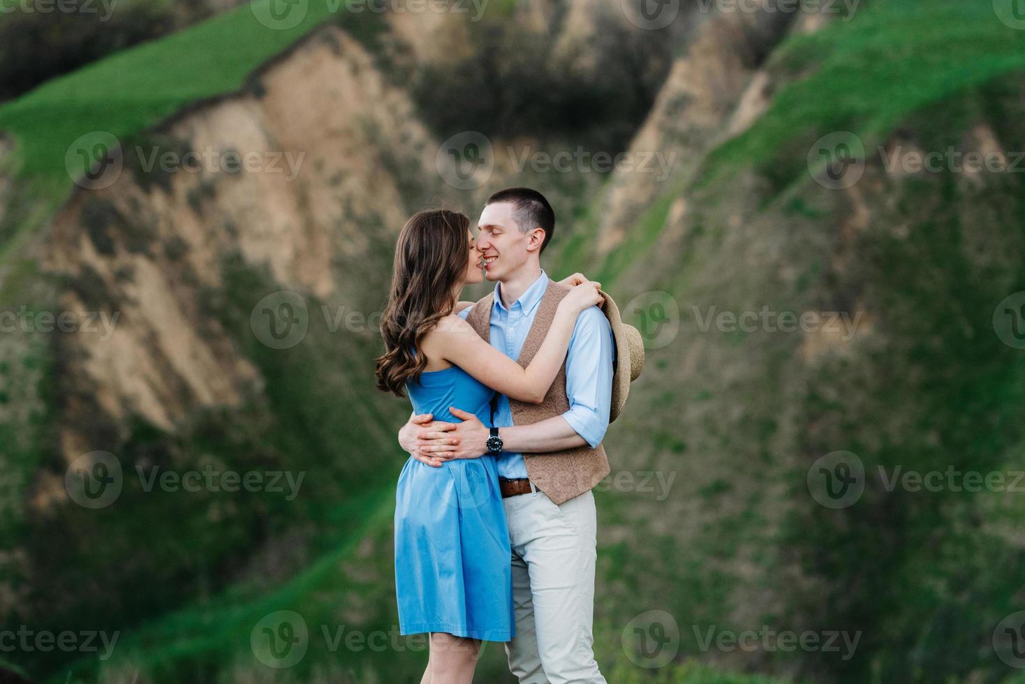 junges Paar, ein Mann und ein Mädchen gehen in den Berghügeln spazieren foto