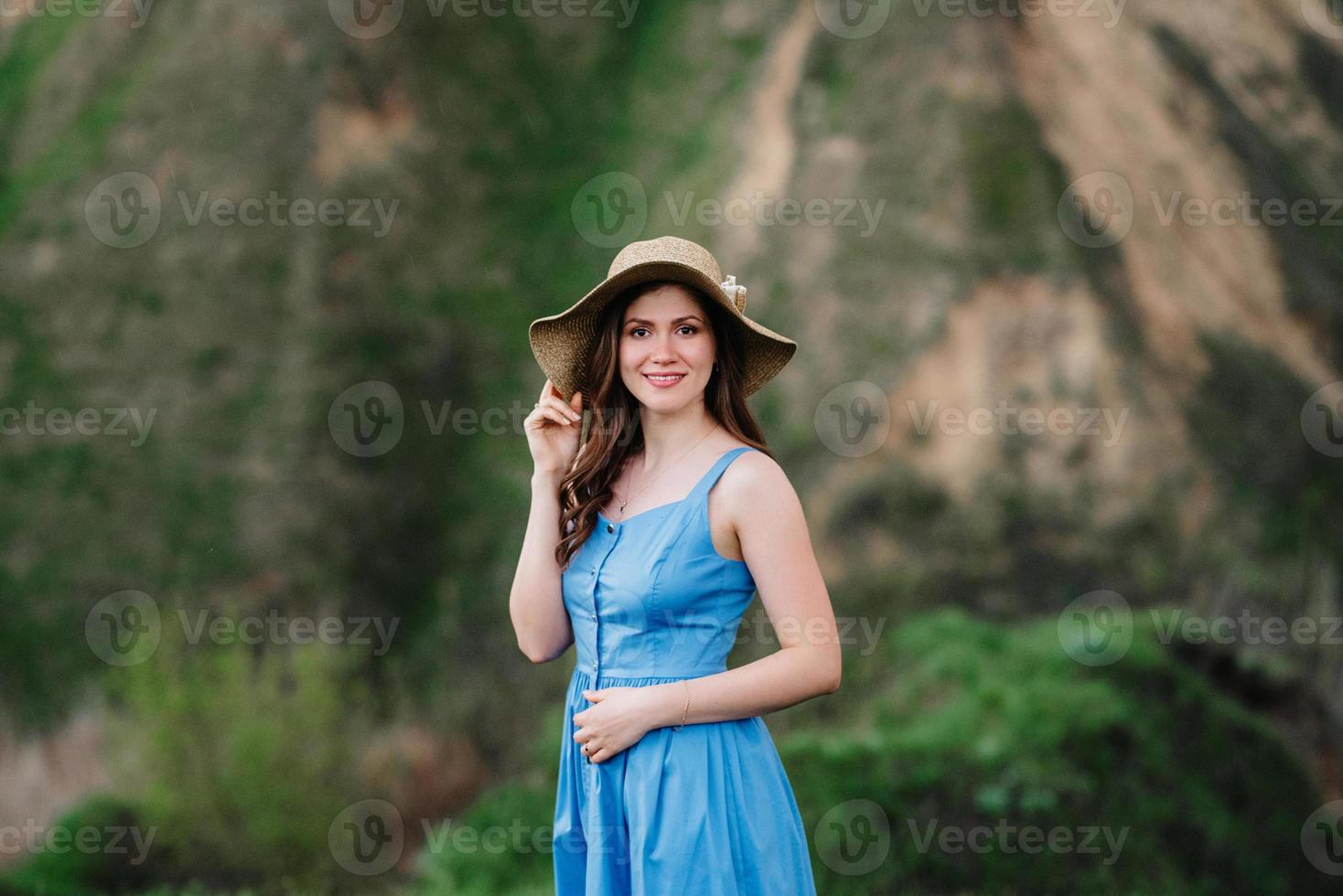 junges Mädchen mit Strohhut mit großer Krempe an Berghängen foto