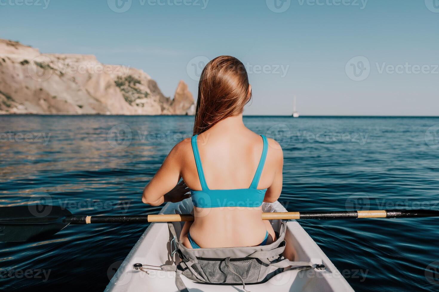 Frau im Kajak zurück Sicht. glücklich jung Frau mit lange Haar schwebend im Kajak auf Ruhe Meer. Sommer- Urlaub Ferien und heiter weiblich Menschen entspannend haben Spaß auf das Boot. foto