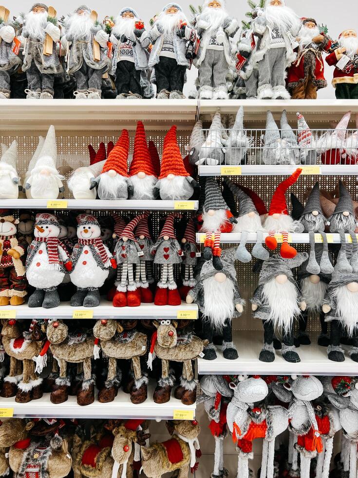 Podgorica, Montenegro - - 25 Dezember 2022. mehrfarbig Figuren von Santa Klaus, Zwerge und Hirsch sind auf das Regale von das Geschäft foto
