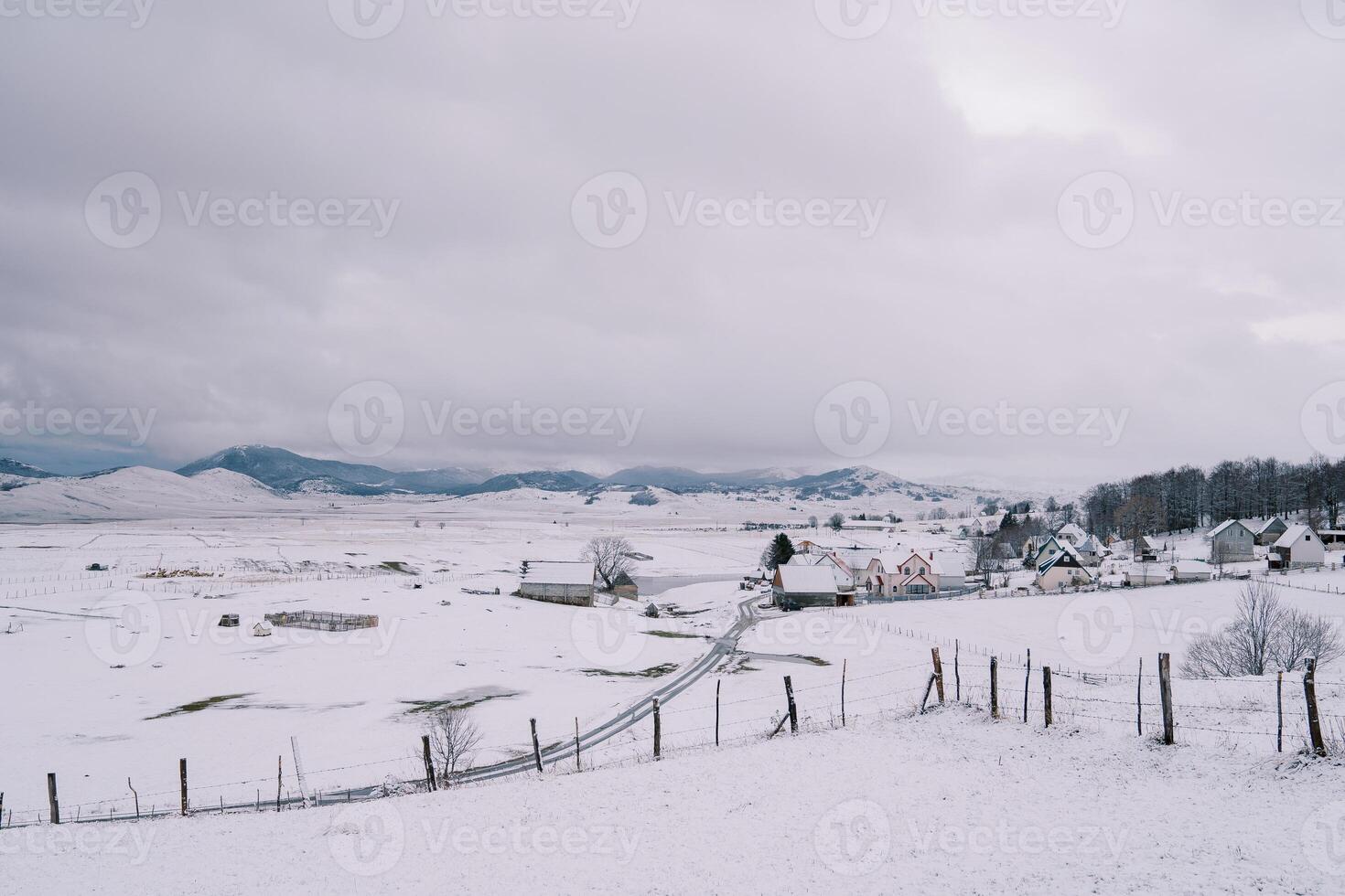 schneebedeckt Straße im ein Dorf auf das Kante von ein Wald im ein Berg Senke foto