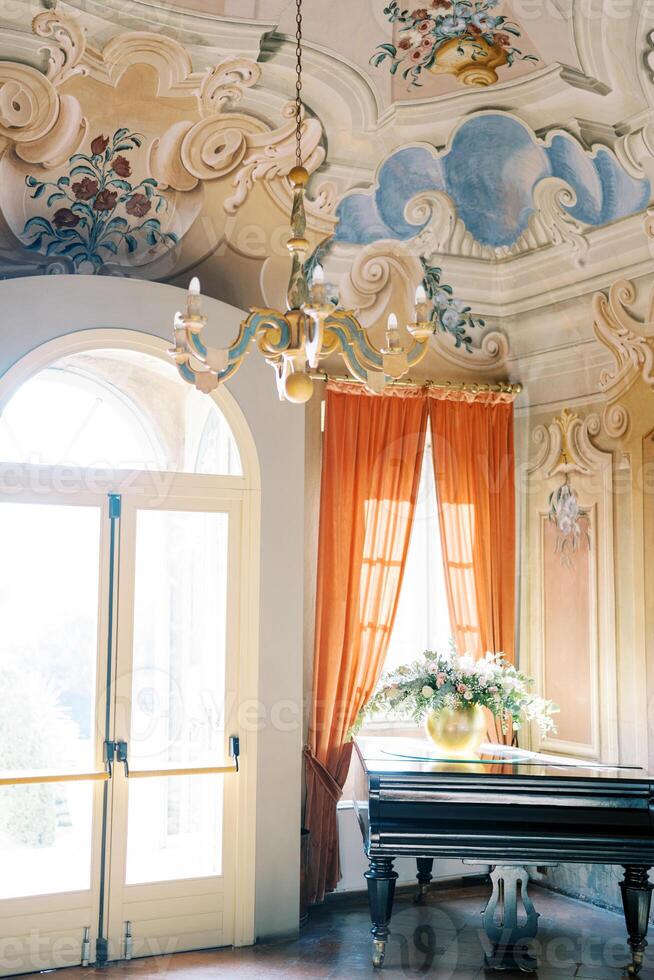 bunt Leuchter hängt von das gemalt Decke von ein uralt Villa. See komm, Italien foto