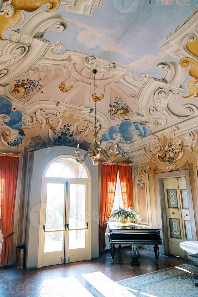bunt gemalt Decke mit Stuck und Leuchter von ein luxuriös uralt Villa. See komm, Italien foto