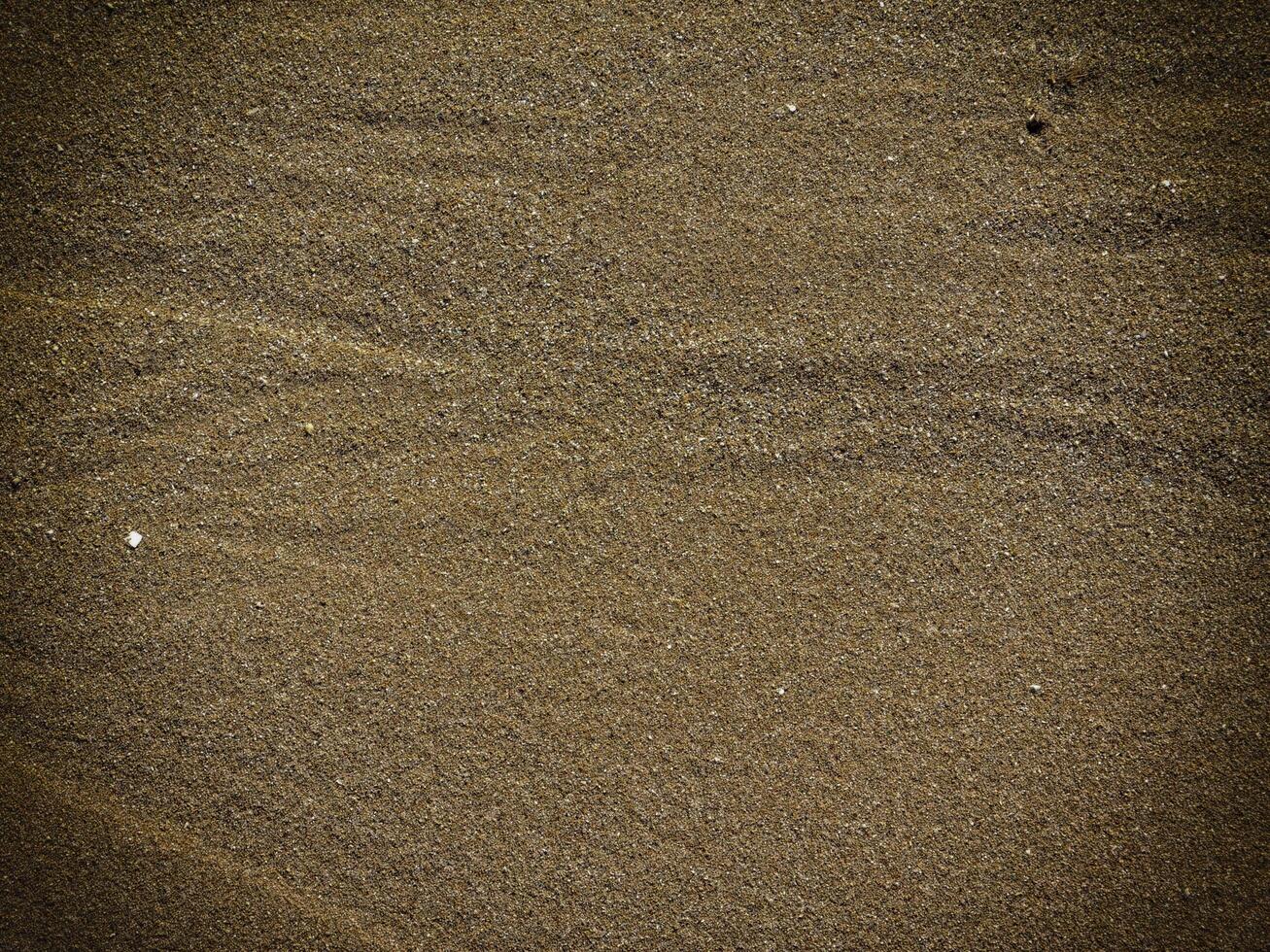 Textur von dunklem Sand am Meer foto