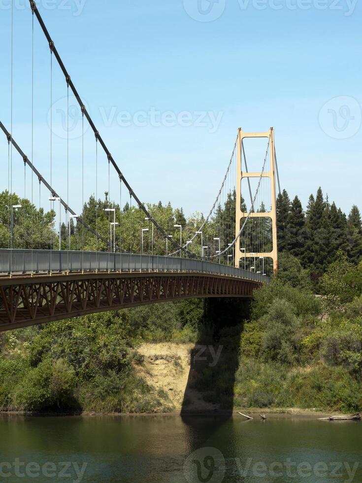 Suspension Gehen Brücke überspannend Fluss Blau Himmel foto