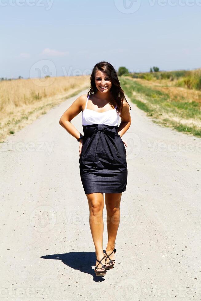 jung kaukasisch Teen Frau Stehen im Kleid auf Kies Straße foto