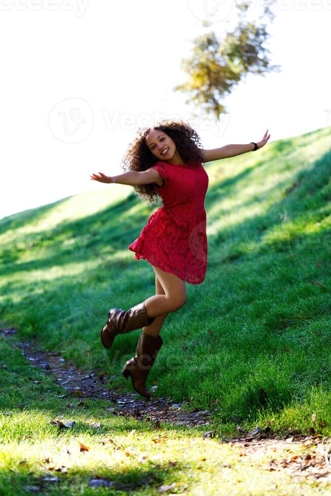 jung Frau Springen draußen im rot Kleid und Stiefel foto
