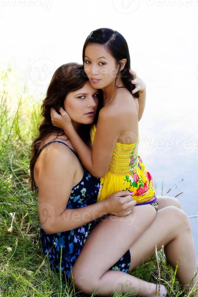 zwei Frauen auf Fluss Bank im Kleider foto