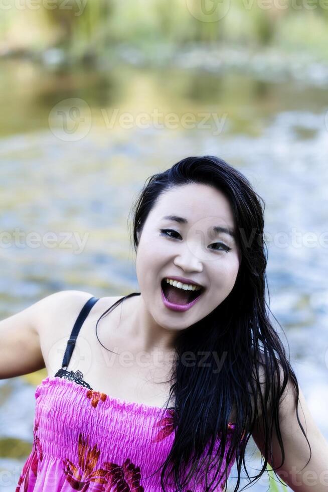 japanisch amerikanisch Frau öffnen Mund Lächeln beim Fluss foto