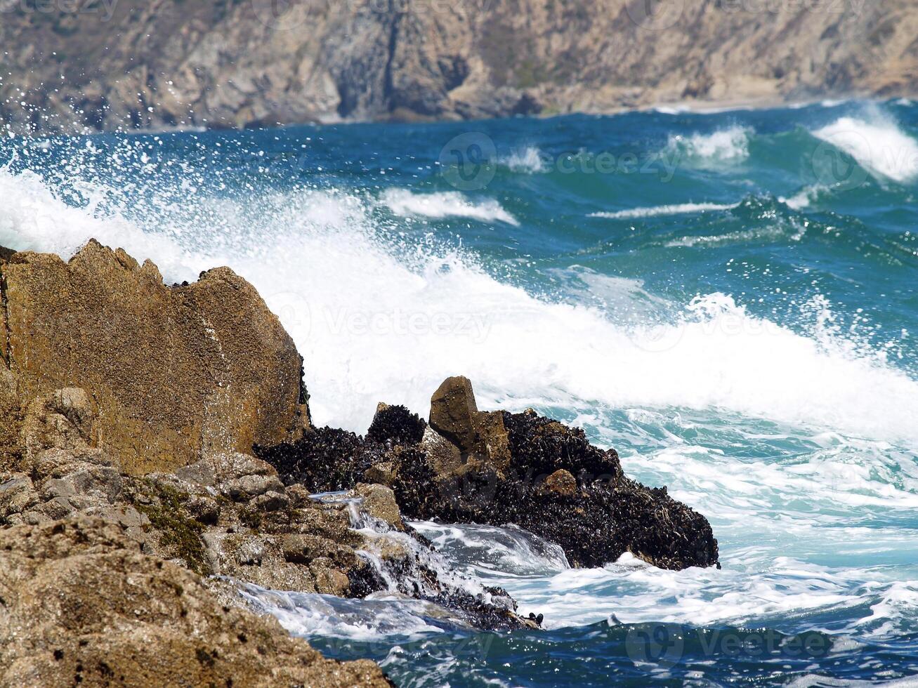 wild Wellen im Bucht gegen felsig Ufer Linie foto