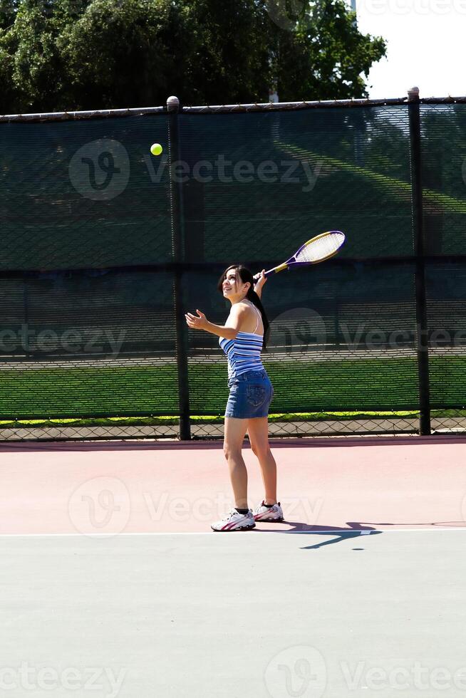 spanisch Teen Mädchen Portion Tennis Ball mit Schläger foto