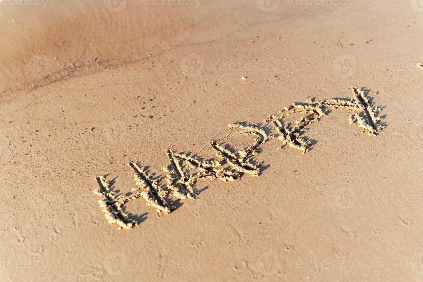 Inschrift 'Glück' auf das Strand Sand wie ein Symbol von Freude und Positivität foto