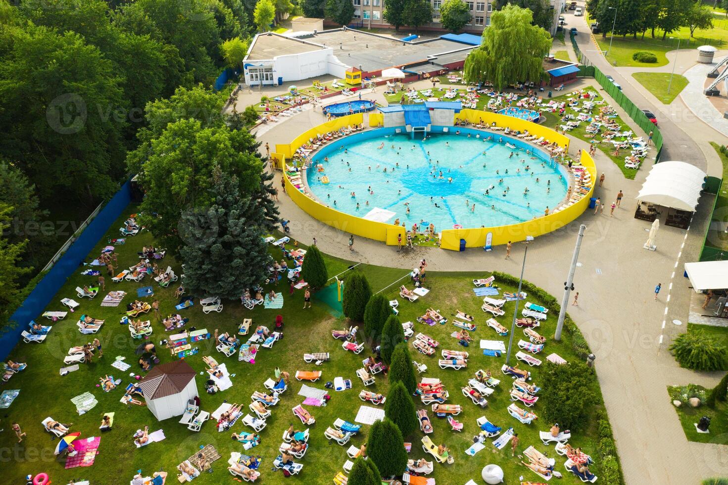 oben Aussicht von ein draussen Platz zum Menschen zu entspannen wo Dort ist ein Schwimmen Schwimmbad und ein Menge von Sonne Betten foto