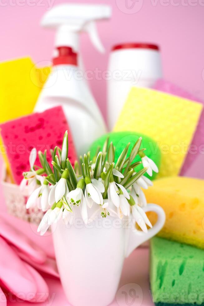 Frühling Blumen und und verschiedene Waschmittel zum Reinigung das Haus auf ein Rosa Hintergrund. Konzept von Frühling Reinigung. Nahansicht. selektiv Fokus. foto