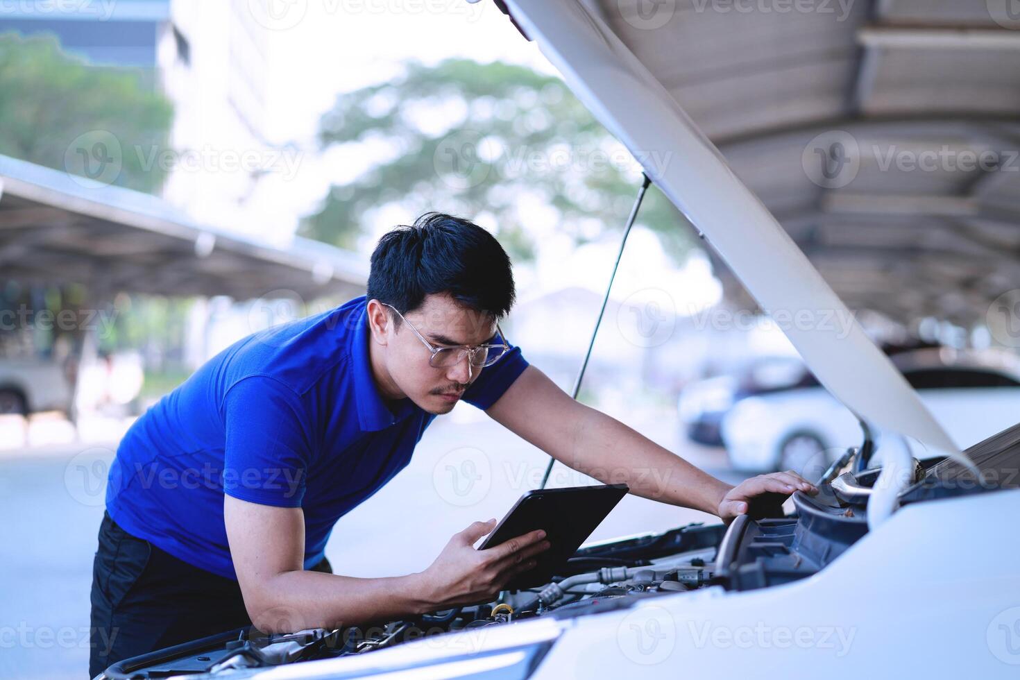 Auto Reparatur Konzept asiatisch männlich Heimwerker im Blau Hemd im Garage Techniker im Auto Reparatur Bedienung Center Mechaniker inspiziert Autos oder Fahrzeuge. foto
