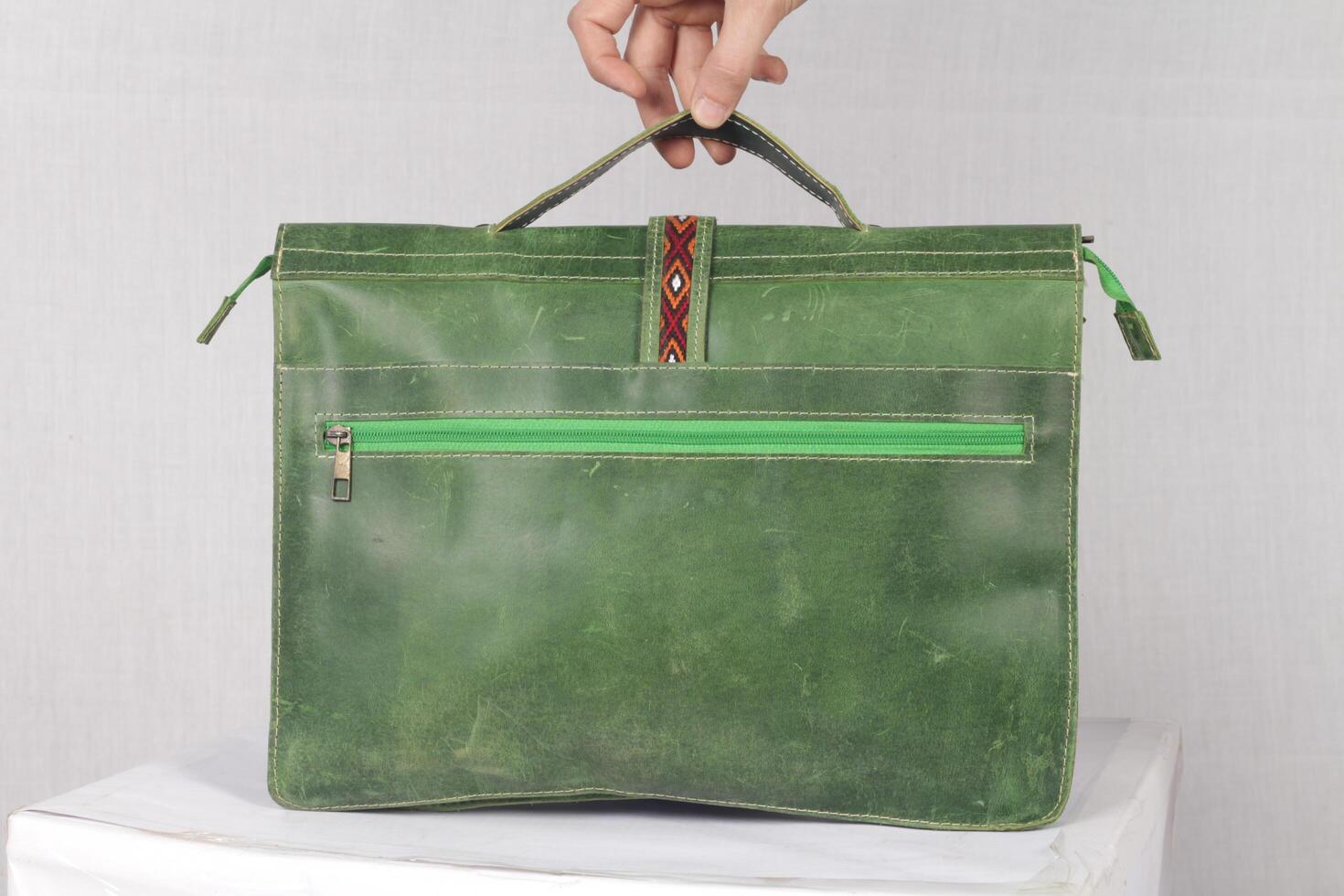 Grün Leder Brieftasche im ein Hand von ein Frau 'S Hand auf ein Weiß Hintergrund foto