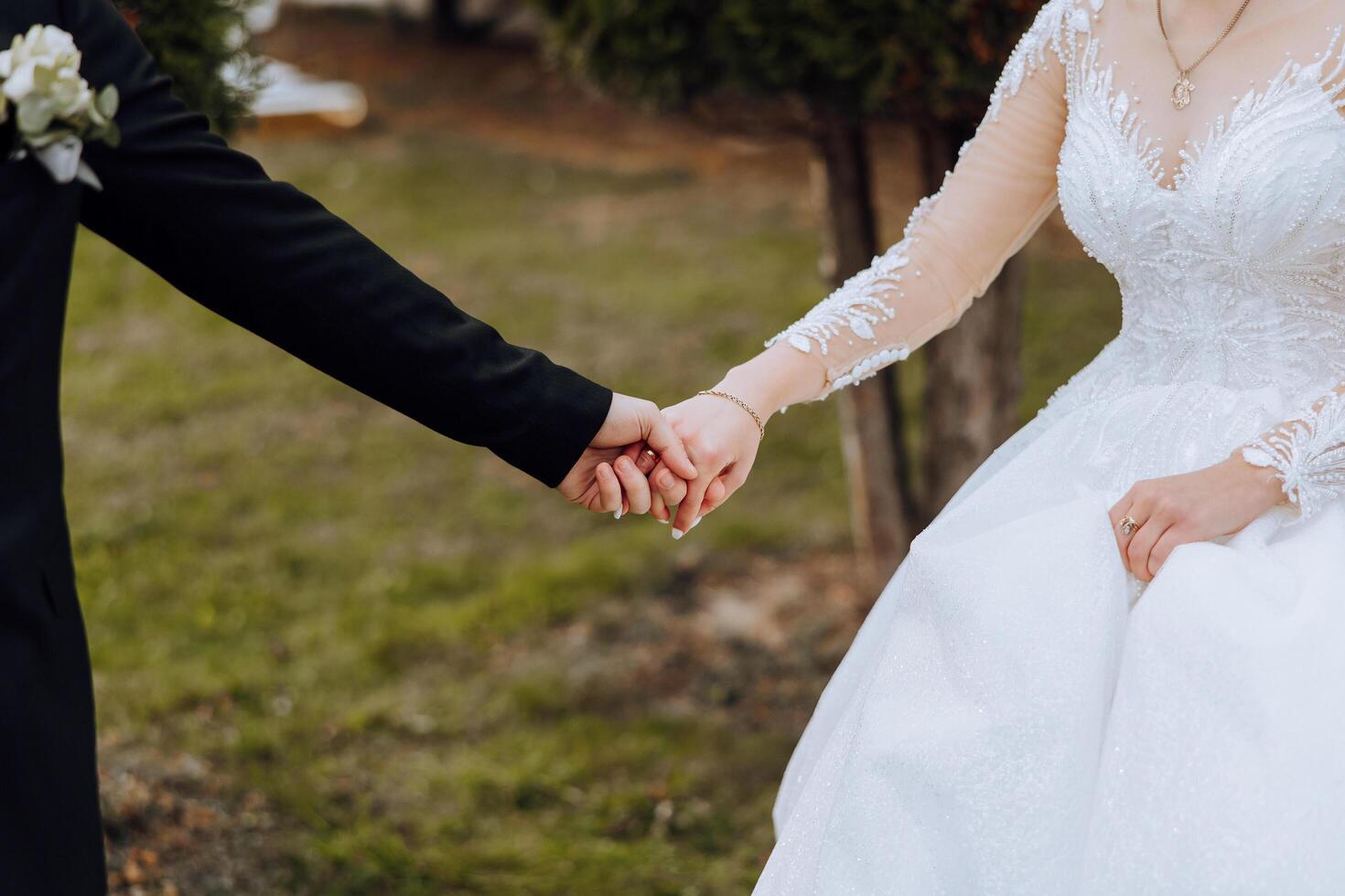 das Bräutigam Küsse das Braut Hand. Hochzeit Foto von ein Paar im Liebe. ein jung und gut aussehend Mann küssen seine Ehefrauen Hand mit ein Gold Ring, vorschlagen.