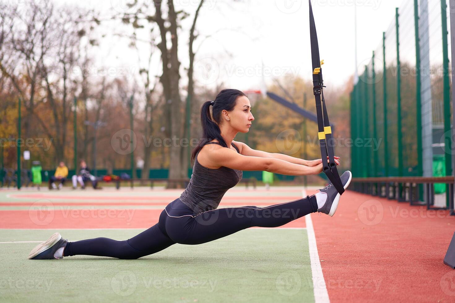 Mädchen Athlet Ausbildung mit trx auf Sportplatz. gemischt Rennen jung Erwachsene Frau tun trainieren mit Suspension System. gesund Lebensstil. Dehnen draußen Spielplatz. foto