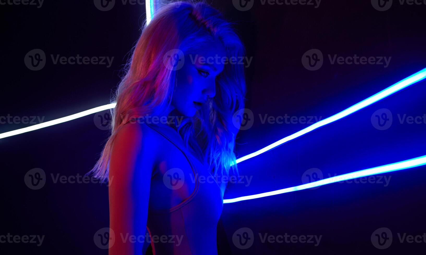 Mode Kunst Foto von sexy Mädchen gekleidet im rot im das Nachtclub. perfekt weiblich Körper mit Neon- Beschriftung auf das Hintergrund