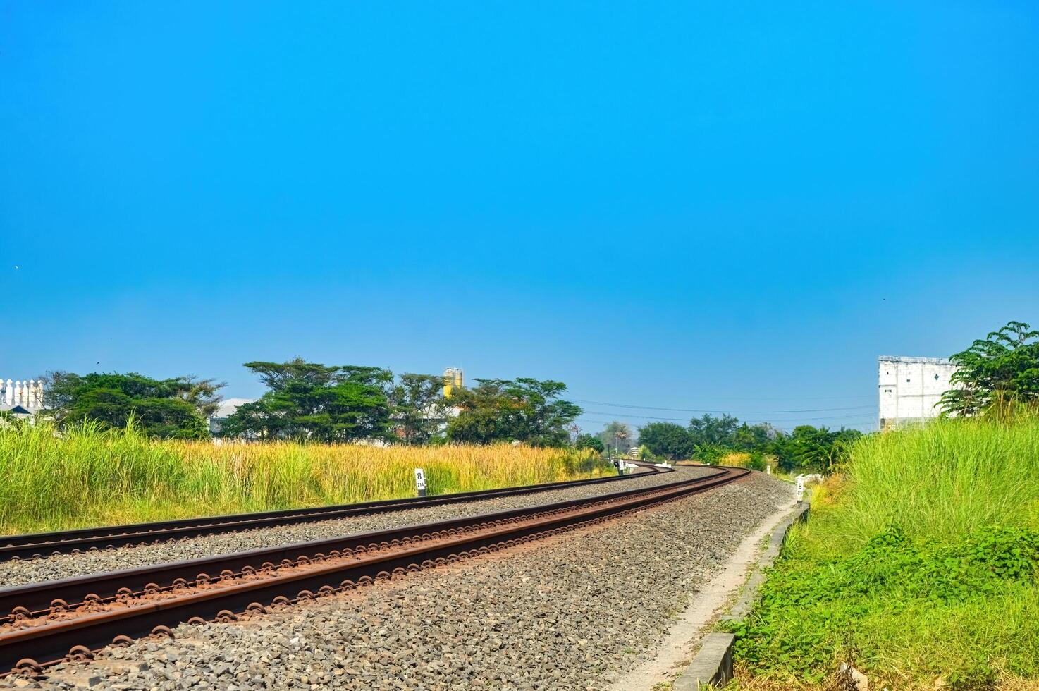 doppelt Spur Eisenbahn Spur Das Kurven über das Norden von das Insel von Java mit ein hell Blau Himmel foto